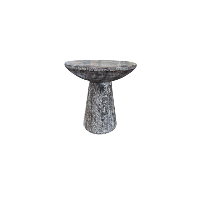 A wonderfully organic round side table. Its pigment was achieved through burning the wood multiple times, adding a white...