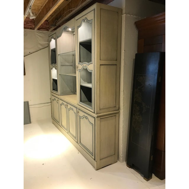 Two piece French country or French provincial breakfront. The bottom portion has three sections. The front middle has two...