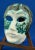 Beautiful wall mask made of majolica-glazed ceramic with white and green enamels, finished with a partially metallic lead-...