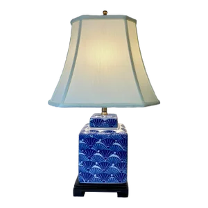 Square Porcelain Ginger Jar Table Lamp Decorated With Festive Blue and White Chinese Fans on a Wooden Base With Cream Colored Lamp Shade