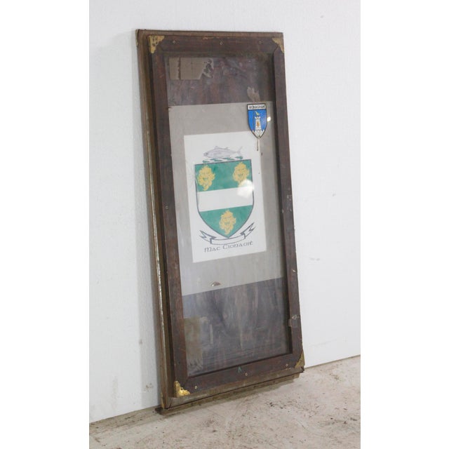 Mac Cionaoit family coat of arms poster with a County Monaghan enamel crest in a vintage billboard display frame. The Mac...