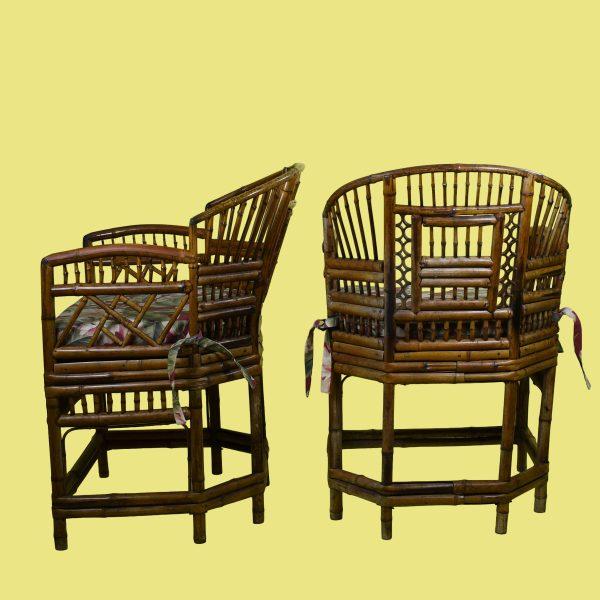 A pair of vintage Brighton Pavilion chairs in dark-stained bamboo with tall, intricately worked backs. The seats wear...