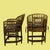 A pair of vintage Brighton Pavilion chairs in dark-stained bamboo with tall, intricately worked backs. The seats wear...