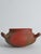 This striking hand-thrown earthenware vessel features an unusual three-handled form and a richly textured surface that...