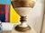 Pair of vintage Grecian themed ceramic lamps with linen shades Lamps are urn shape sitting on a square pedestal base Lamp...