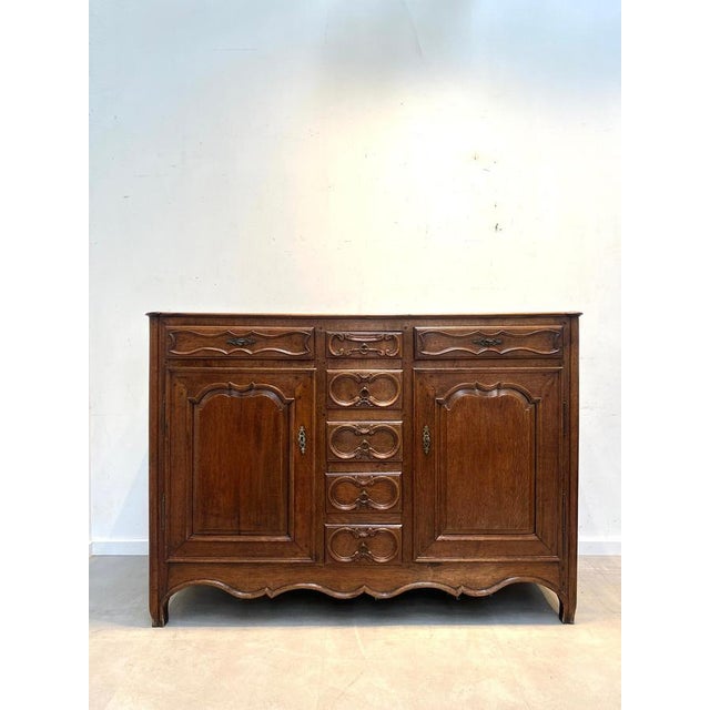 Beautiful antique rustic sideboard in solid oak, featuring a warm medium-brown patina and elegant carved details...