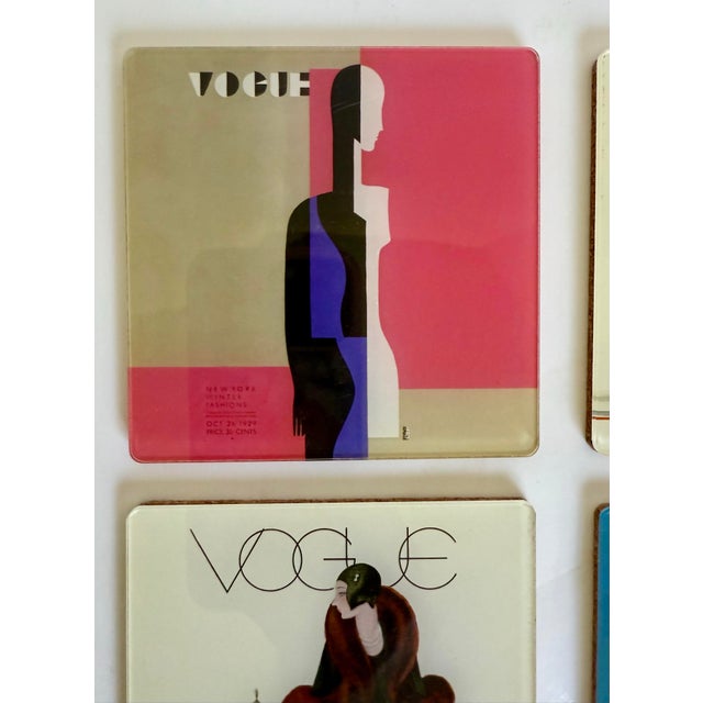 Here is a stylish set of four vintage 1980s coasters featuring iconic 1929 Vogue magazine covers, reproduced in vivid...