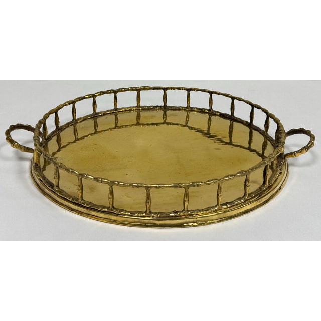Large polished vintage mid-century modern round brass tray with faux bamboo rail edge and handles. Lovely patina.