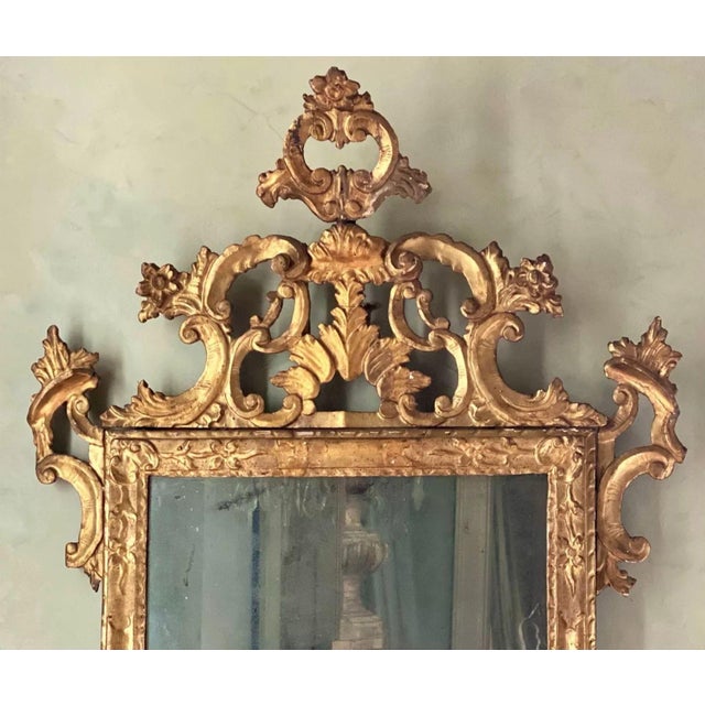 Exceptional 18th century Rococo giltwood mirror from Lucca, Italy, retaining its original mercury glass plate. The finely...