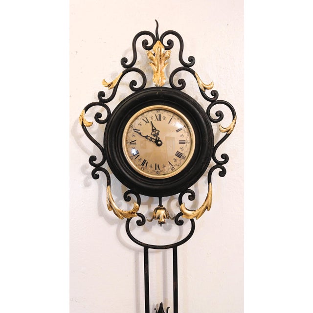Vintage French style wrought iron wall clock with gold accented floral and scrolling leaf accents. The dial is protected...