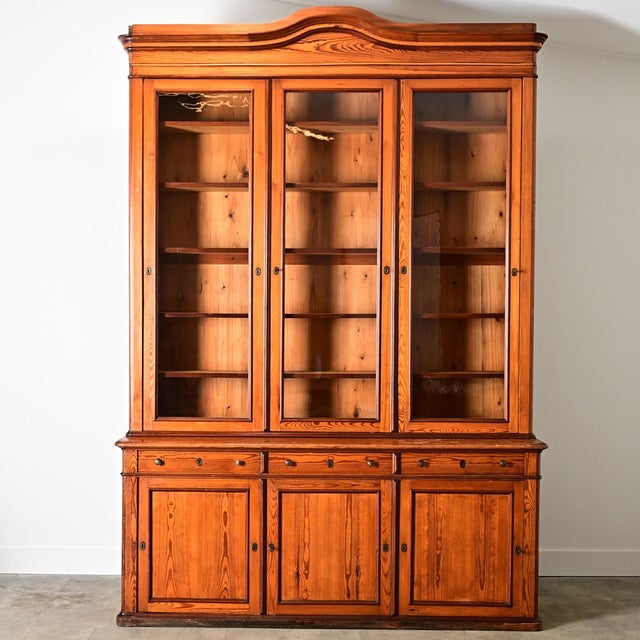 A towering, French 19th century Louis Philippe period bibliothèque, handcrafted from pine which has natural luminosity...