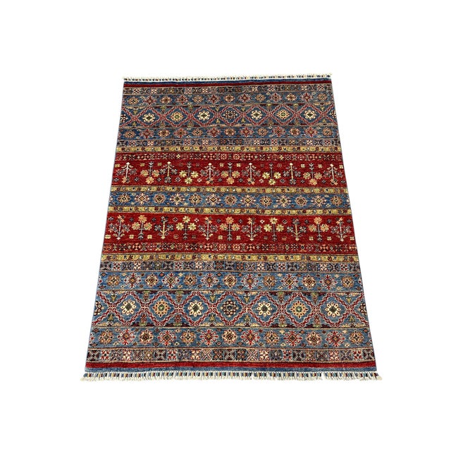 This naturally dyed wool area rug features a Khorjin saddlebag design inspired by Persian tribal weaving. Horizontal bands...