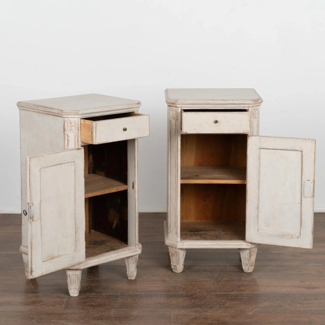 Pair, small Swedish country Gustavian style white painted nightstands or small cabinets standing on tapered feet. Canted...