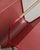 A rare french mid century modern magazine rack in red lacquered p erforated sheet metal with brass feet and handle...