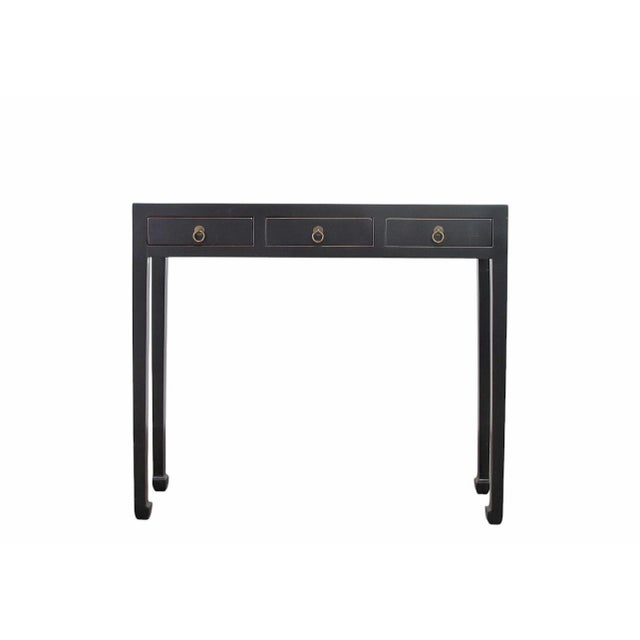 This vintage console table features three side-by-side storage drawers, each accented with traditional metal hardware and...
