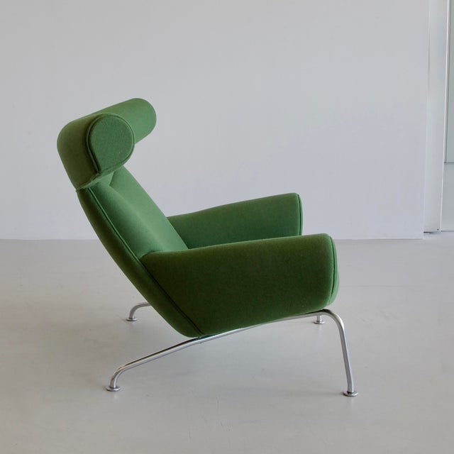 Vintage Ox-Chair with footstool in recent green wool upholstery and tubular steel frame. The chair remained in production...