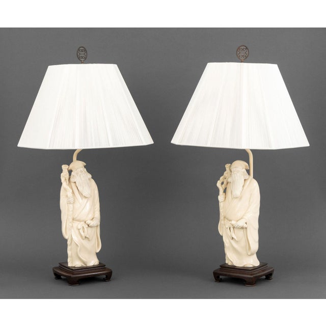 Pair of James Mont Style Figural Ceramic Sculpture Mounted Table Lamps, each depicting the figure of Shouxing mounted on a...