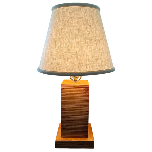 1970s craftsman-made stacked plywood laminate table lamp. The lamp showcases the natural beauty of layered wood grain in a...