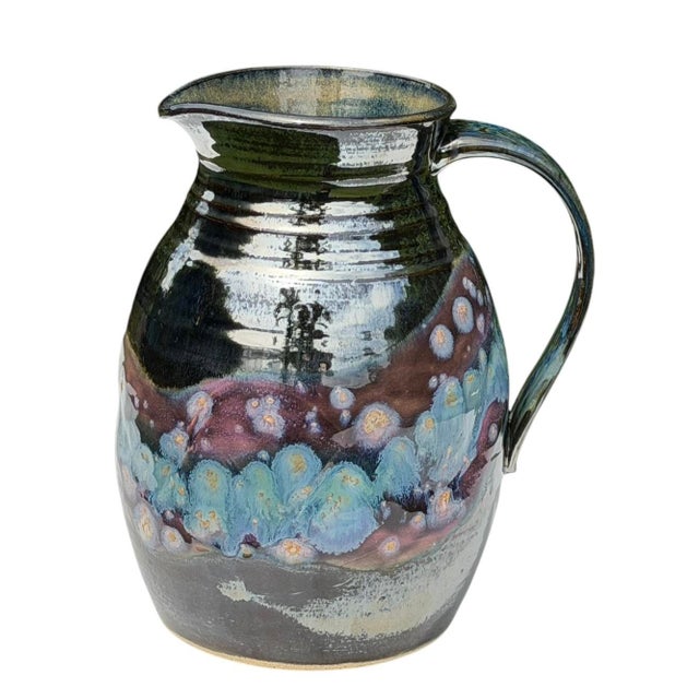 A striking vintage studio pottery pitcher featuring an expressive crystalline glaze in layered shades of cobalt blue,...