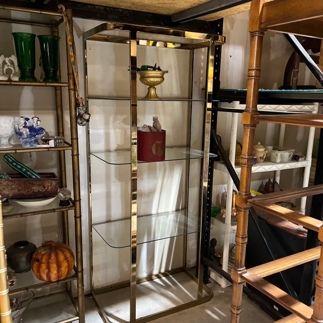 Up for consideration is a beautiful vintage Art Deco gold metal bookcase with glass shelves. This would look lovely in...