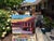 This artwork depicts a vibrant exterior of a house, characterized by bold colors and geometric forms that create a sense...