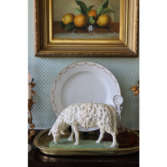 A wonderfully sculptural vintage grazing sheep, hand-painted in time-softened antique ivory and mounted on its original...