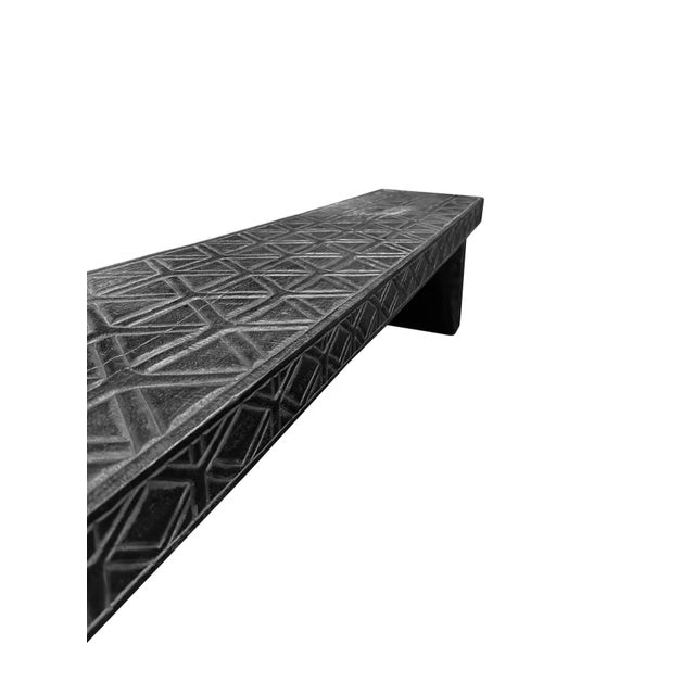 A sculptural hand-carved mango wood bench. To achieve is rich black pigment the bench was burnt three times and then...