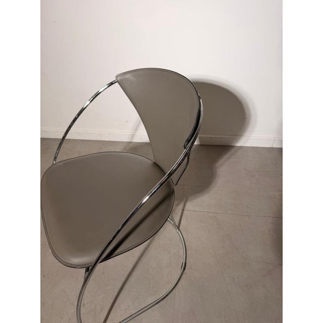Elegant Italian dining chair by Amben Italy , featuring a sculptural tubular chrome frame combined with grey leather...