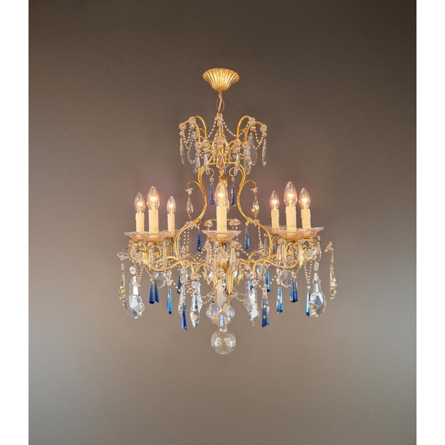 This decorative chandelier is designed in the Venetian style with Rococo Revival influences, featuring gracefully curved...