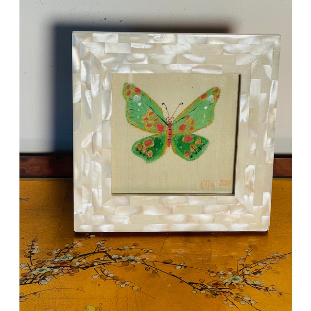 Lovely butterfly painting on canvas in a mother of pearl tasselated frame.