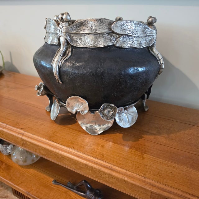 A striking Art Nouveau-style jardiniere combining dramatic botanical ornament with substantial sculptural metalwork. A...