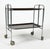 This bar cart has a chromed steel frame with plastic trays and folds up completely. While the piece is unmarked, likely...