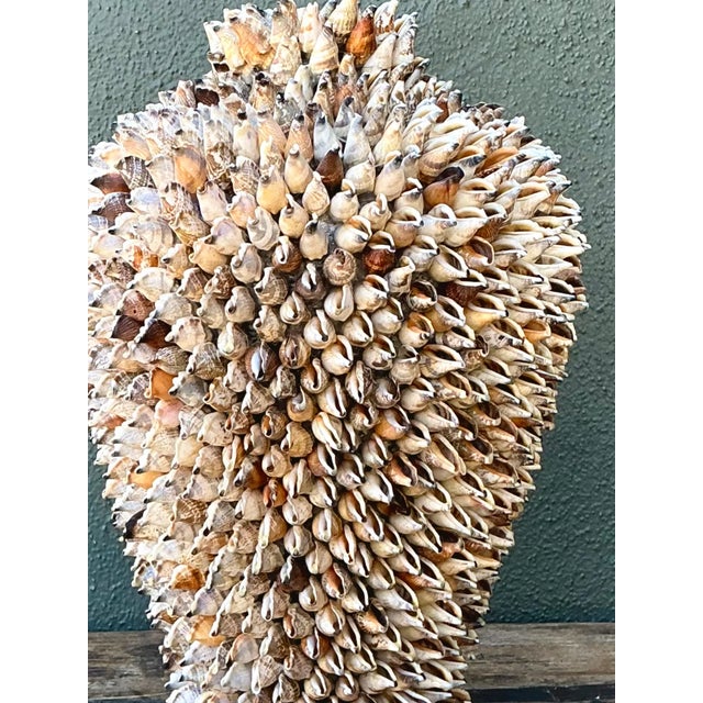 Showcasing intricate coastal folk artistry, this vintage mid-century urn-form sculpture is densely encrusted with...