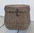 The pot-belly shape, inset side handles, and front latch mechanism of this vintage basket mimic the silhouette of a...