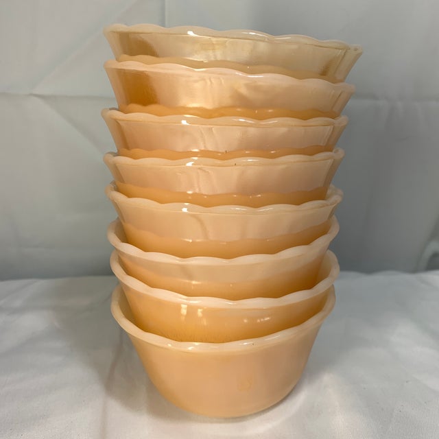 These are vintage Fire-King Peach Lustre scalloped custard cups (model 424) featuring a glossy iridescent peach finish and...