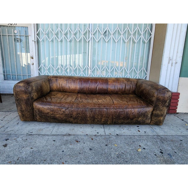 Distressed Leather Sofa with a Worn Brown Finish, this has a low-profile silhouette and deep seating. The Leather With...