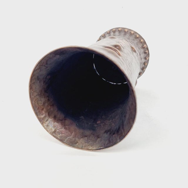 Totem-shaped, decorated, hammered copper vase from the 1970s. A stylized human face can be seen in its material, with a...