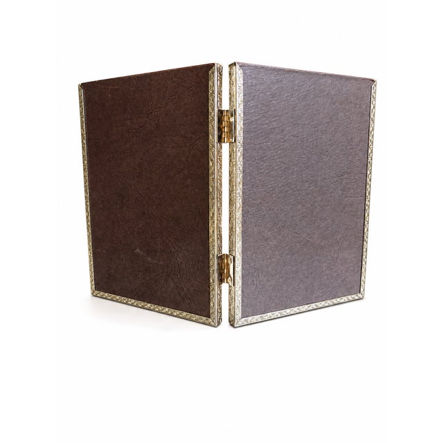 Elegant vintage double picture frame crafted in gold-tone metal with decorative neoclassical-style detailing and glass...