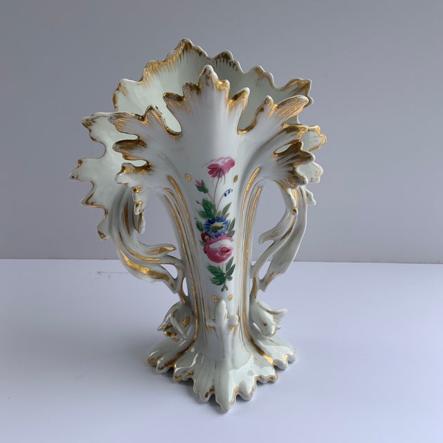 Strikingly sculpted vases with hand painted flowers and gold painted flourishing at every edge.