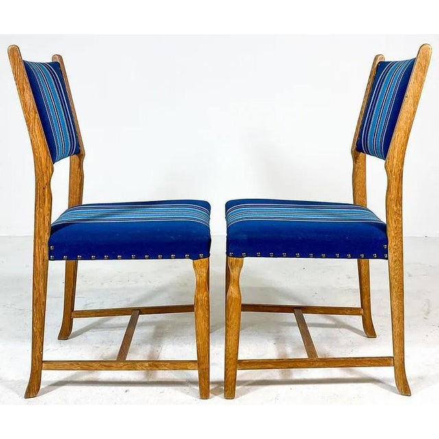A beautiful and sleek set of 6 Danish modern dining chairs. The chairs are of carved and figured oak and are upholstered...