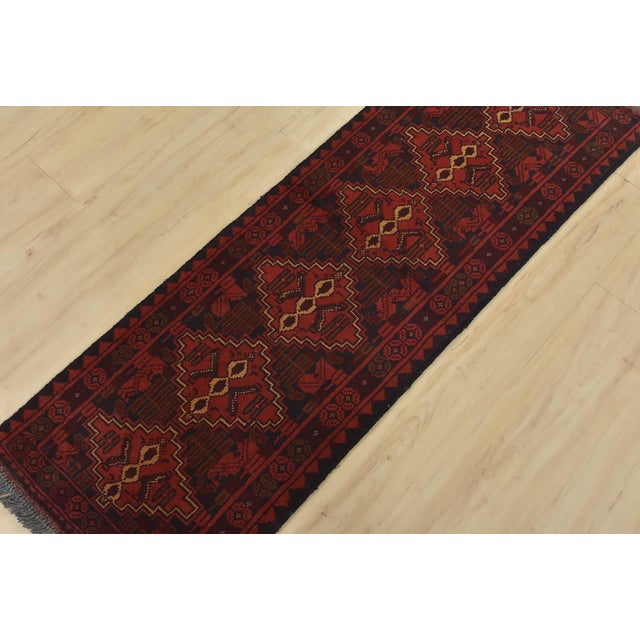 An authentic tribal Turkmen runner hand-knotted with an all-wool pile on a cotton foundation. This oriental rug features a...