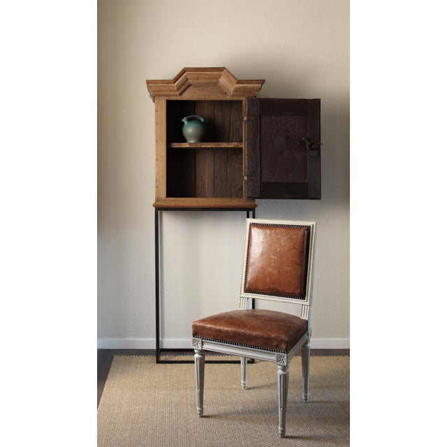 Scraped back to its original wood, this striking cabinet makes a bold statement in any setting. The antique body is...