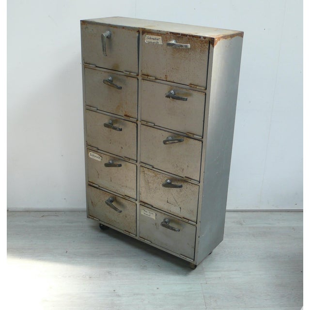 Vintage metal cabinet with 10 drop-down doors on casters, suitable as a workshop cabinet or loft kitchen, etc., from the...