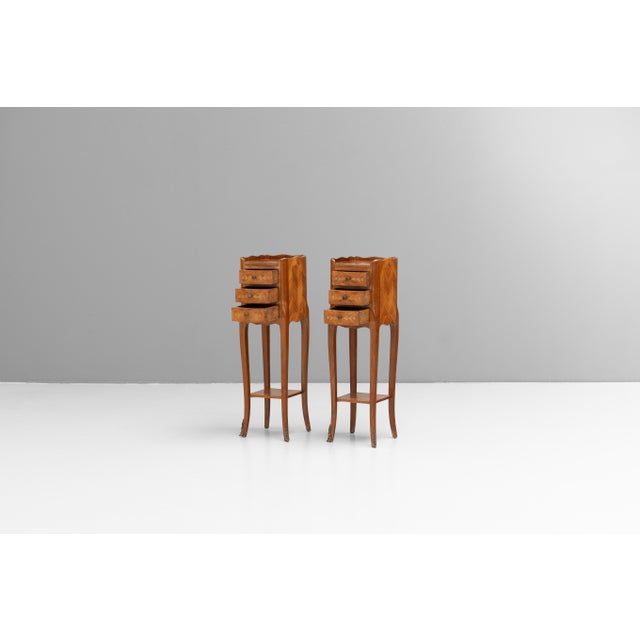 Pair of French small sized inlaid walnut three drawer bedsides. Circa 1950.
