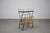Elegant mid-century rolling magazine rack cart produced in Czechoslovakia in the 1970s. The cart features a black metal...