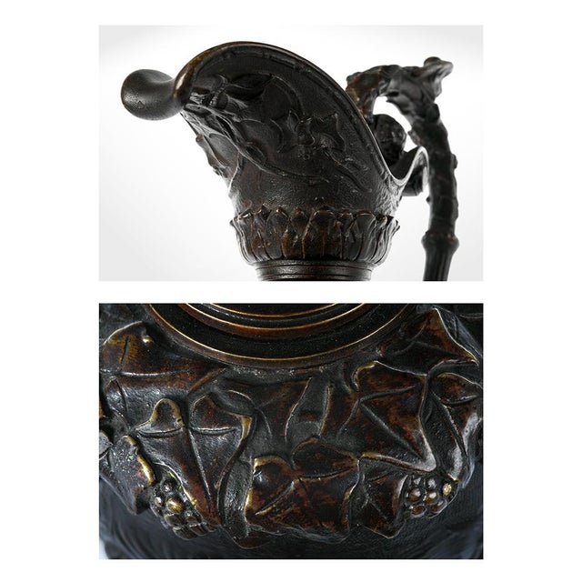Ewer in patinated bronze with a mythological subject featuring a round of putti and Bacchantes celebrating the grape...
