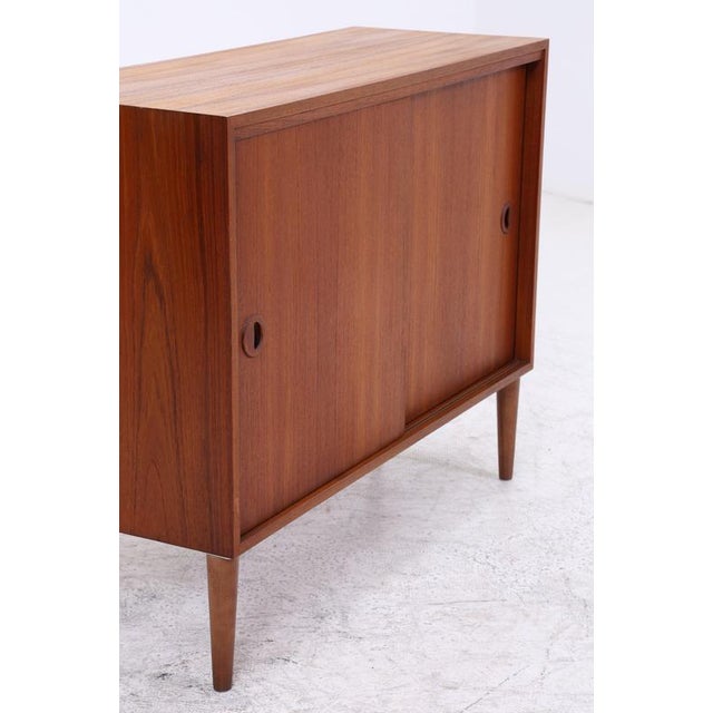 Vintage chest of drawers from Musterring with two smooth-running sliding doors and beautiful teak grain. Its clean lines...