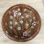 Vntage Italian footed bowl crafted from ceramic with a hand-painted floral design featuring pink blossoms and green leaves...