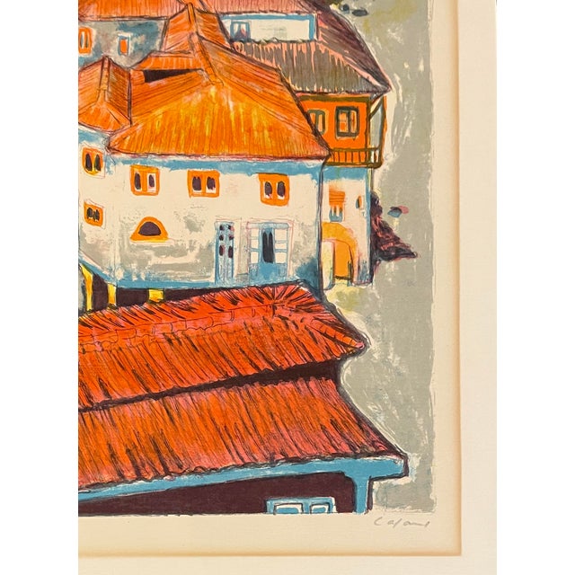 1960s lithograph of a European tile roofed village. Pencil signed illegibly and numbered 196 of 260. Combined shipping...
