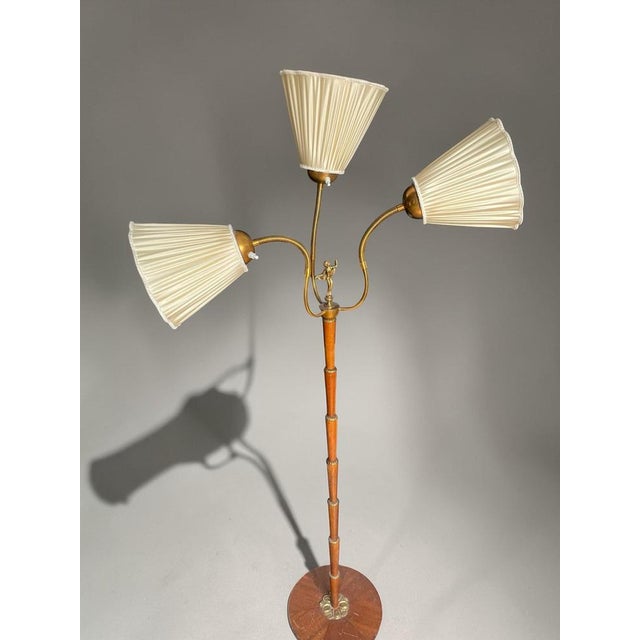 Striking Swedish Art Deco floor lamp from the 1940s, crafted in a refined combination of brass and teak. The design...